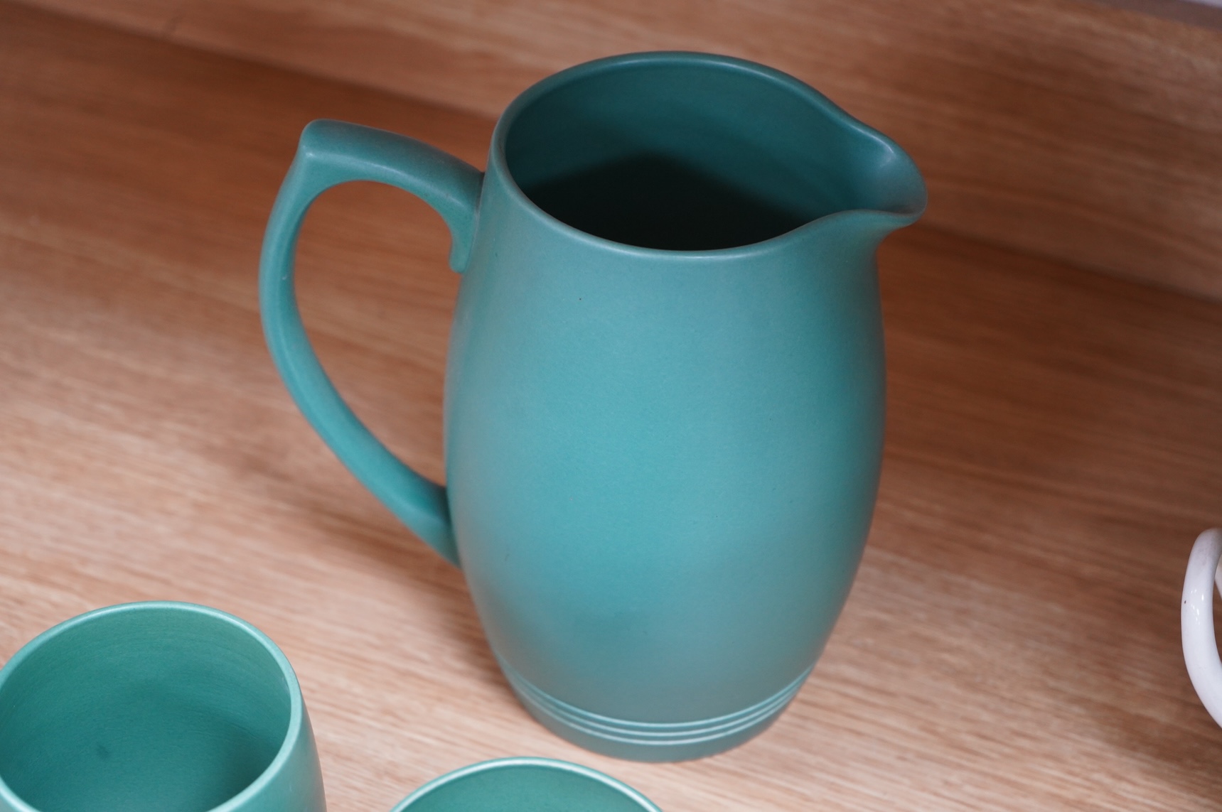 Keith Murray for Wedgwood green glazed lemonade jug and four green mugs, largest 21cm high
